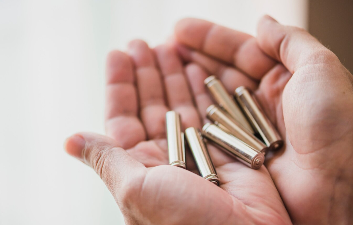close-up-hands-holding-alkaline-battery-cells